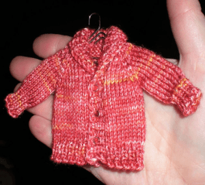 mini shawl collar that fits on the palm of a hand, knitted in pink sock yarn