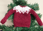 mini Westie sweater in red with white yoke, against a green pine tree
